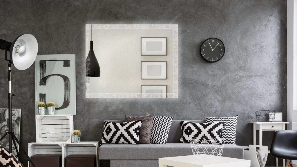 Modern living room with a geometrical light up mirror for wall, a couch, and a wall clock in Ajman.