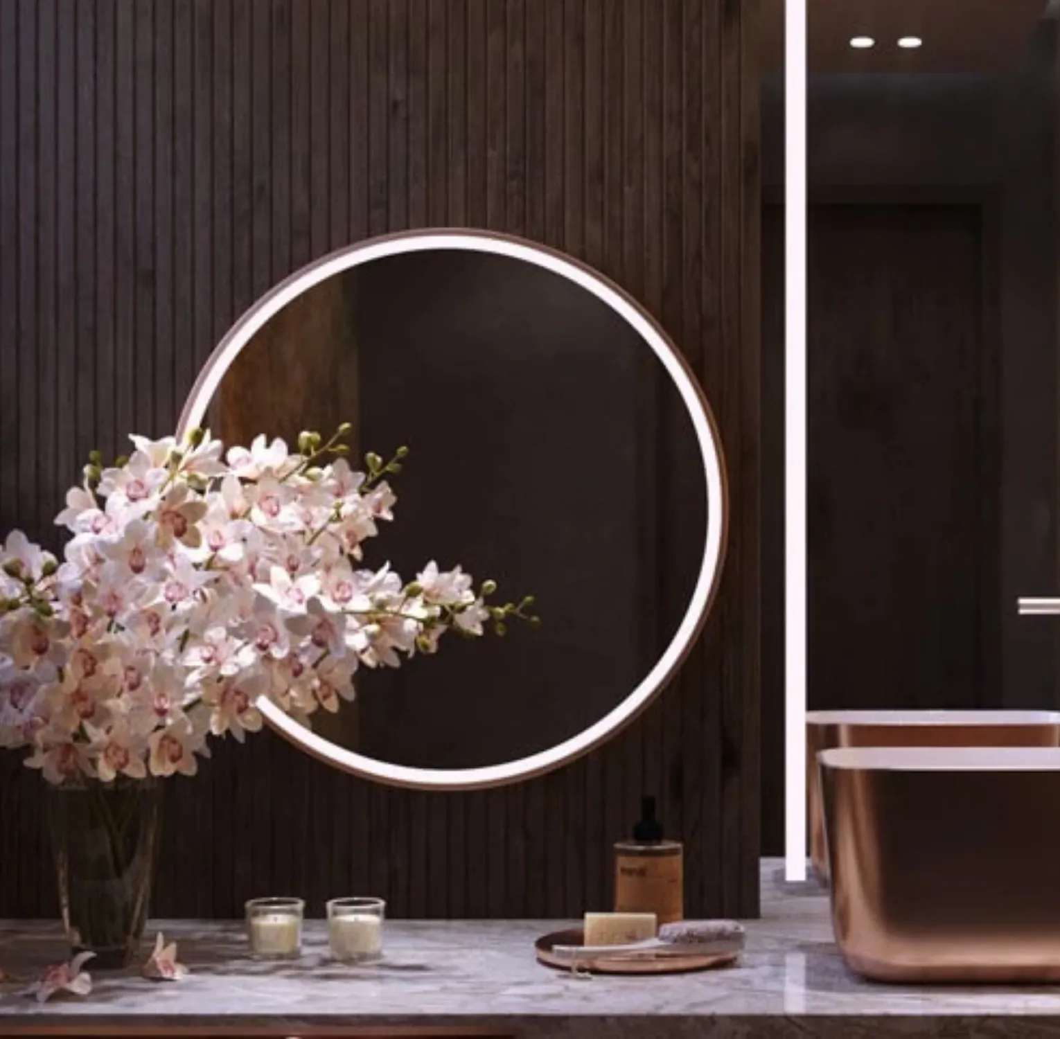 A lighted round mirror with gold frame in dubai