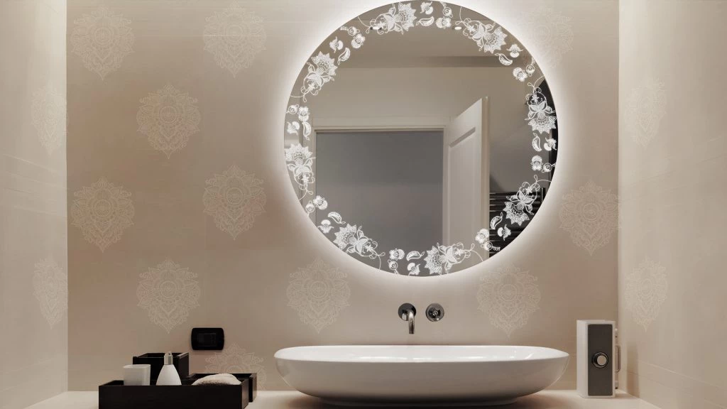 Fancy bathroom with a paisley light up mirror for wall inset on a wall and a sink below in Sharjah.