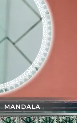 Circular front lit mirror with mandala patterned LED light mounted on a red wall in Saudi Arabia.